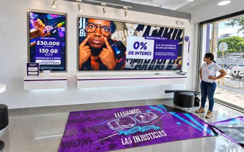 Retail store with large-format graphic pieces installed on the wall and floor, next to a team member