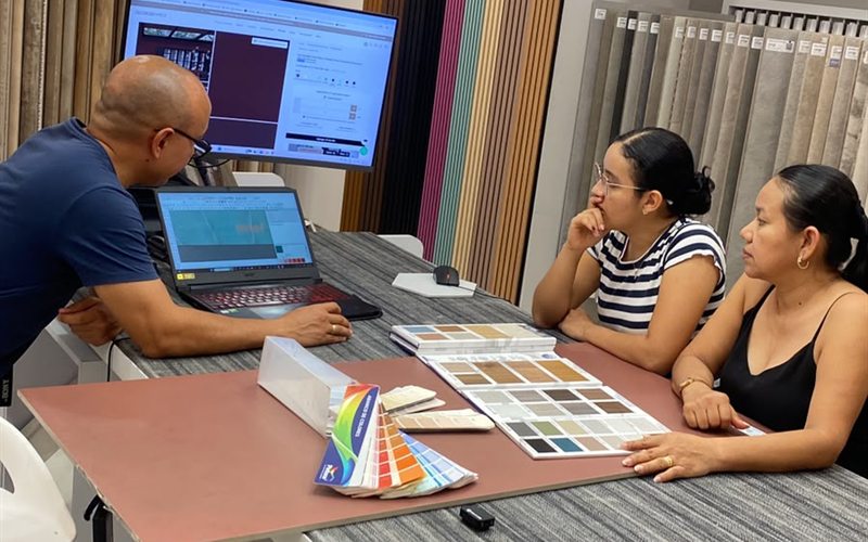 Consulting meeting with color samples and a screen alongside two clients